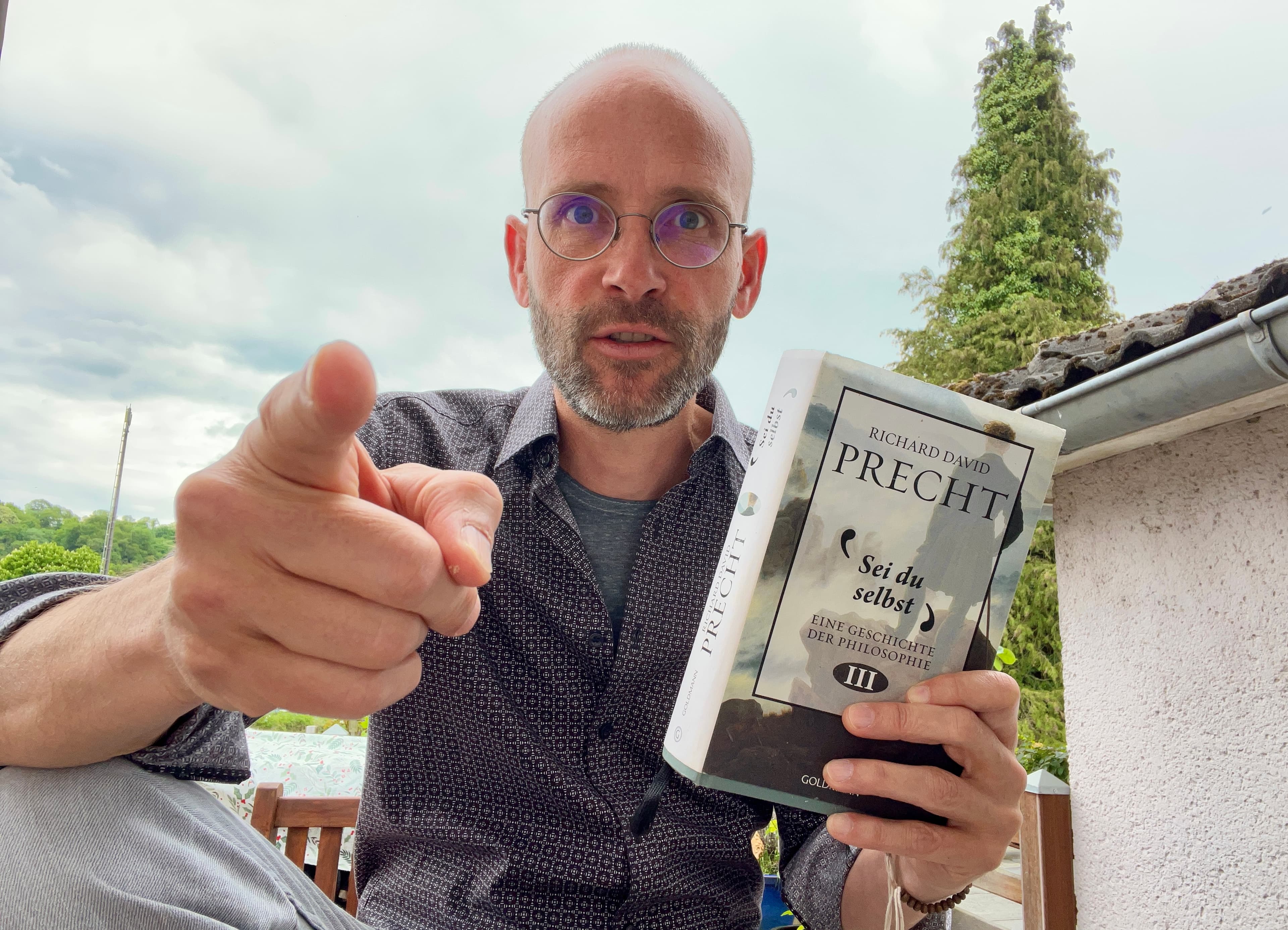 Sean Kollak hält Richard David Prechts 'Sei du selbst' in die Kamera – Philosophiegeschichte Band III als Impuls für Sum Credo